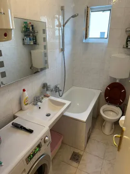 Smaller bathroom with a bathtub, sink, and toilet. - image 7