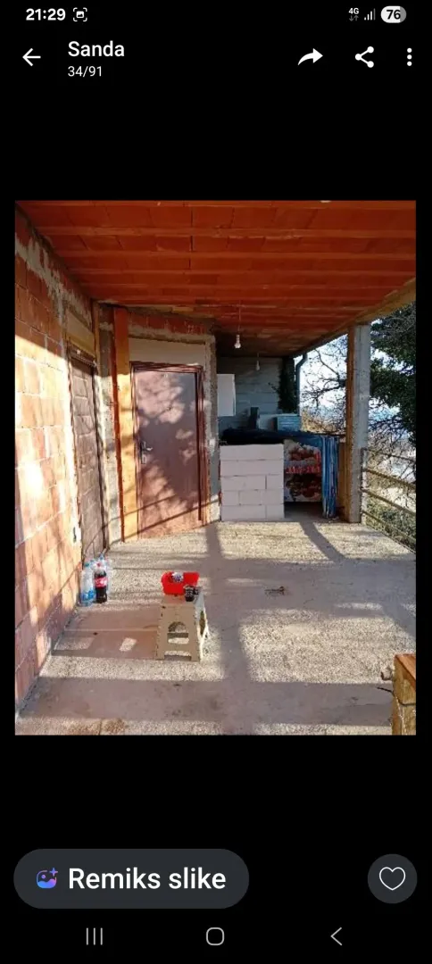Natkrivena terasa u izgradnji sa betonskim podom i ciglenim zidovima.