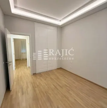 Empty room with a built-in wardrobe and laminate flooring. - image 3