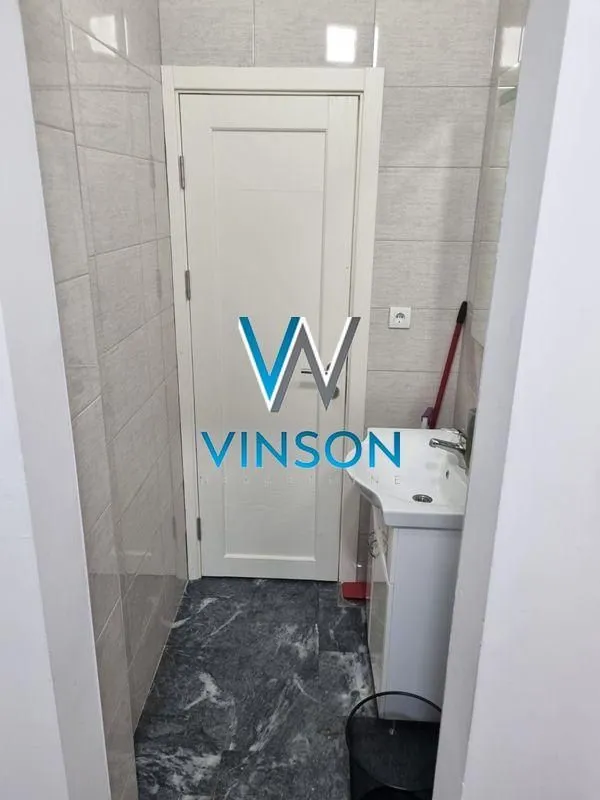 Smaller bathroom with a sink and white door.