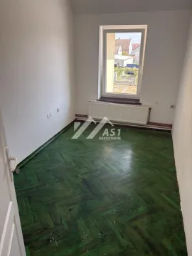 Empty room with green parquet flooring and a single window. - image 8