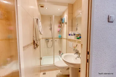 Smaller bathroom with a shower cabin, washbasin, and toilet. - image 19