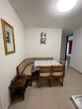 Dining area with a corner bench, table, and chairs. - image 4