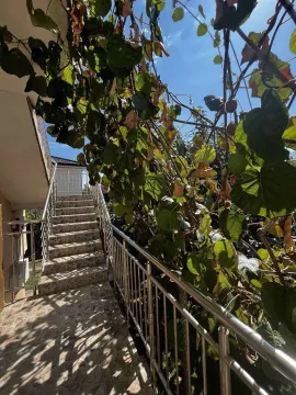 Vanjske stepenice sa metalnom ogradom okružene zelenilom. - image 3