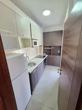 Manja opremljena kuhinja sa bijelim i tamnim elementima i frižiderom. - image 10