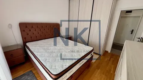 Furnished bedroom with a double bed, wardrobe, and nightstands. - image 5