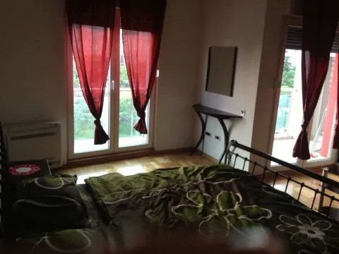 A bedroom with balcony access and red curtains. - image 6