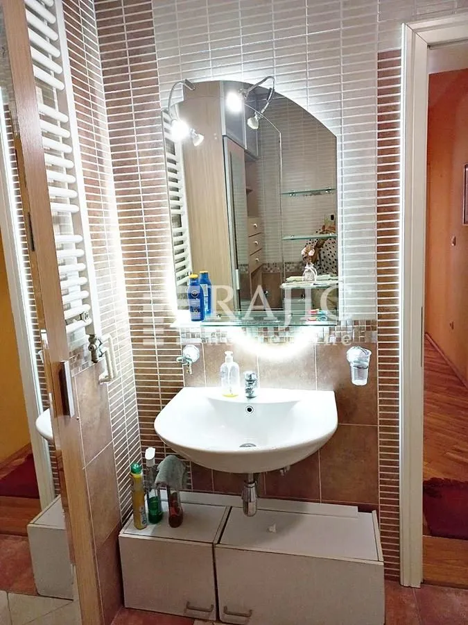 Small bathroom with a sink, mirror, and tiles.