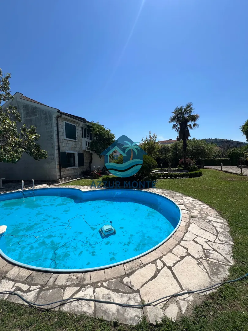 Exterior of the house with a swimming pool and landscaped yard.