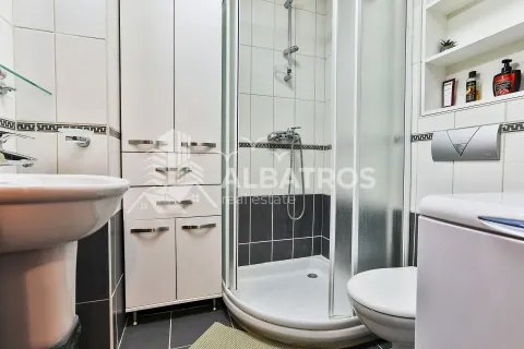 Kompaktno kupatilo sa tuš kabinom, umivaonikom, toaletom i bijelim ormarićem. - image 12