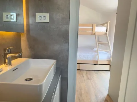 View from the bathroom into a bedroom with a bunk bed. - image 14