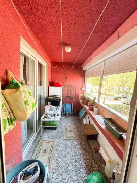 Zastakljeni balkon sa crvenim zidovima i prostorom za odlaganje. - image 11