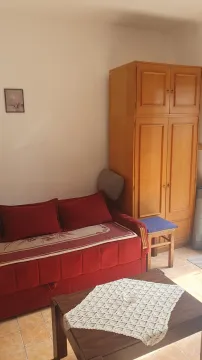 Dnevni boravak sa crvenim kaučem, drvenim ormarom i stočićem. - image 6