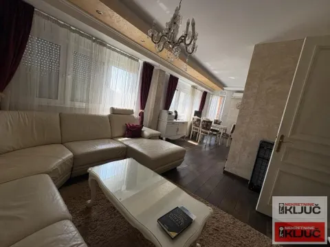Prostrani dnevni boravak sa garniturom za sedenje i trpezarijskim delom u pozadini. - image 4