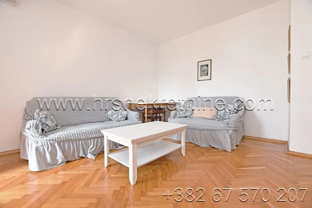 Living room with a sofa set and parquet flooring.