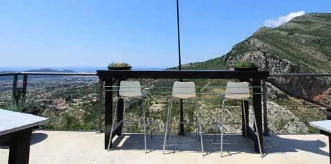 Terasa sa visokim stolom i stolicama sa koje se pruža pogled na planinski pejzaž. - image 20