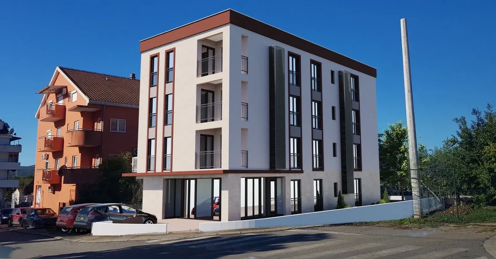 Exterior view of a modern residential building with balconies and parking in front.
