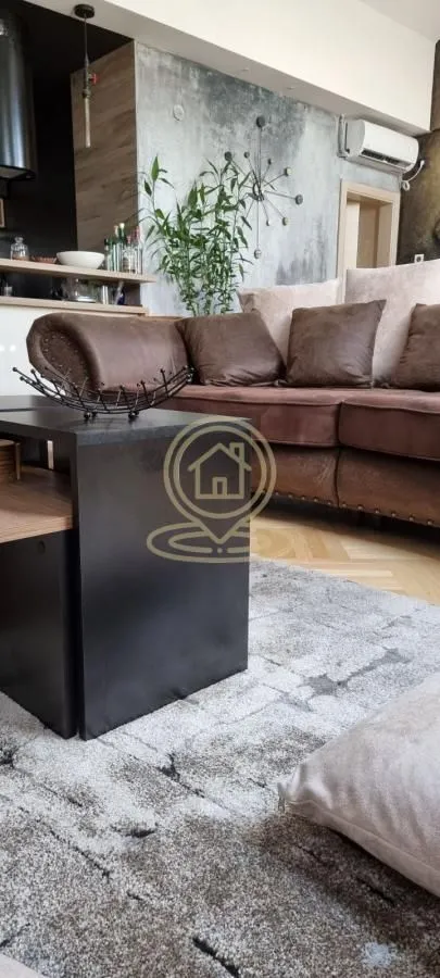 Living room with a sectional sofa, coffee table, and decorative elements on the wall.