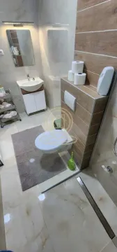 Moderno opremljeno kupatilo sa tuš kabinom, umivaonikom i WC šoljom. - image 4