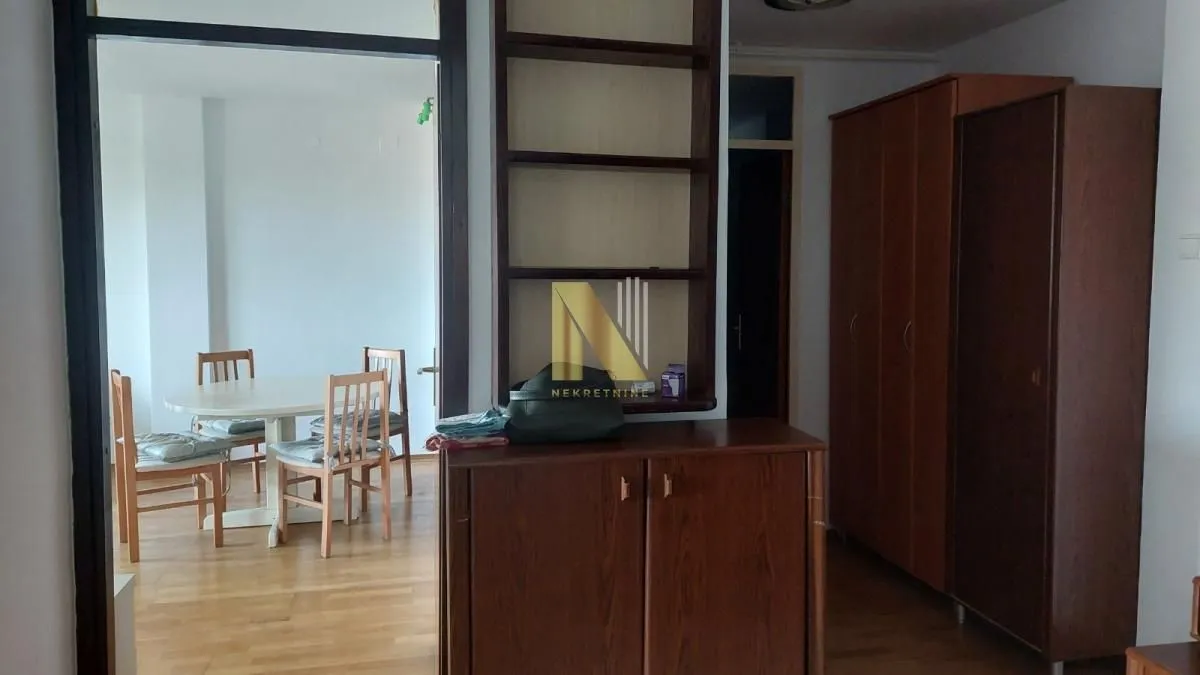 Living room with dining area and wooden furniture.