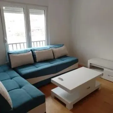 A bright living room featuring a blue sectional sofa and a white coffee table. - image 14
