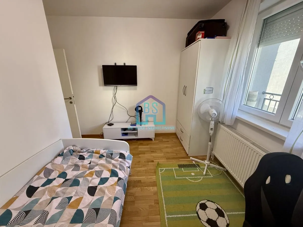 Dečja spavaća soba sa krevetom, garderoberom, radnim stolom i televizorom.