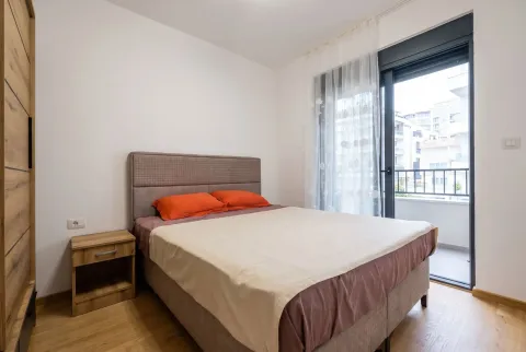 Modern bedroom with a double bed and balcony access. - image 8