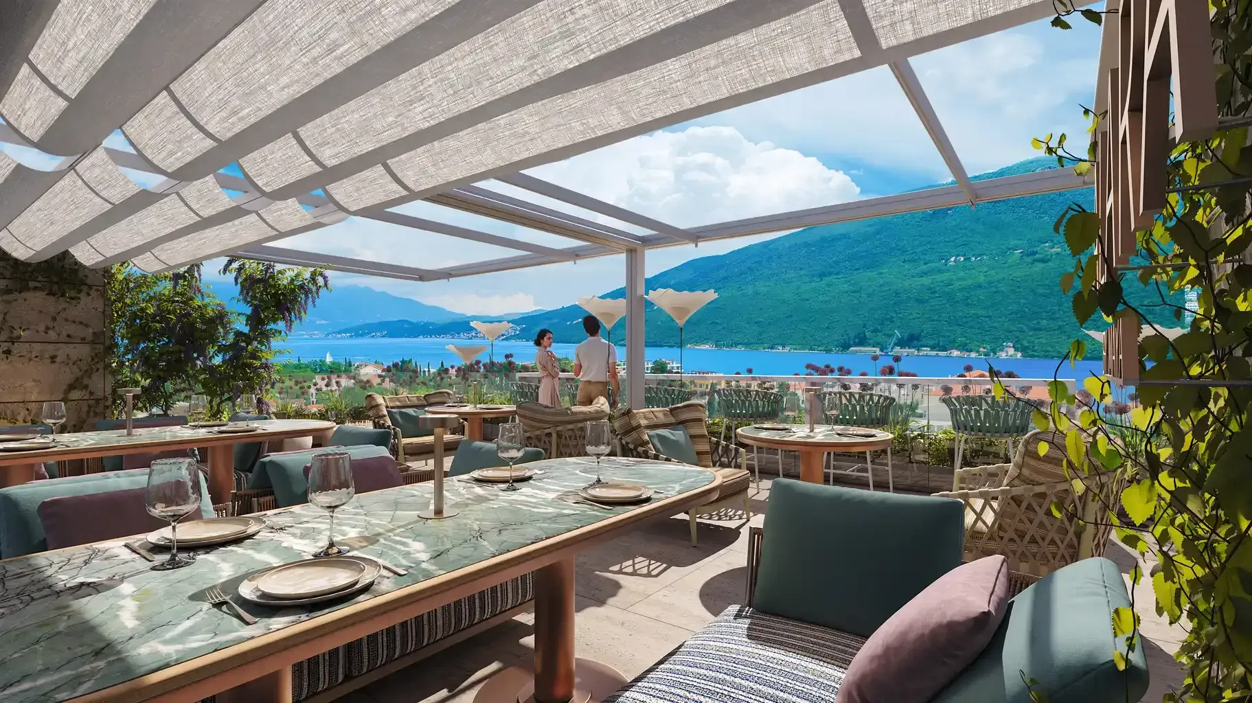 Namještena terasa restorana sa pogledom na more i planine.