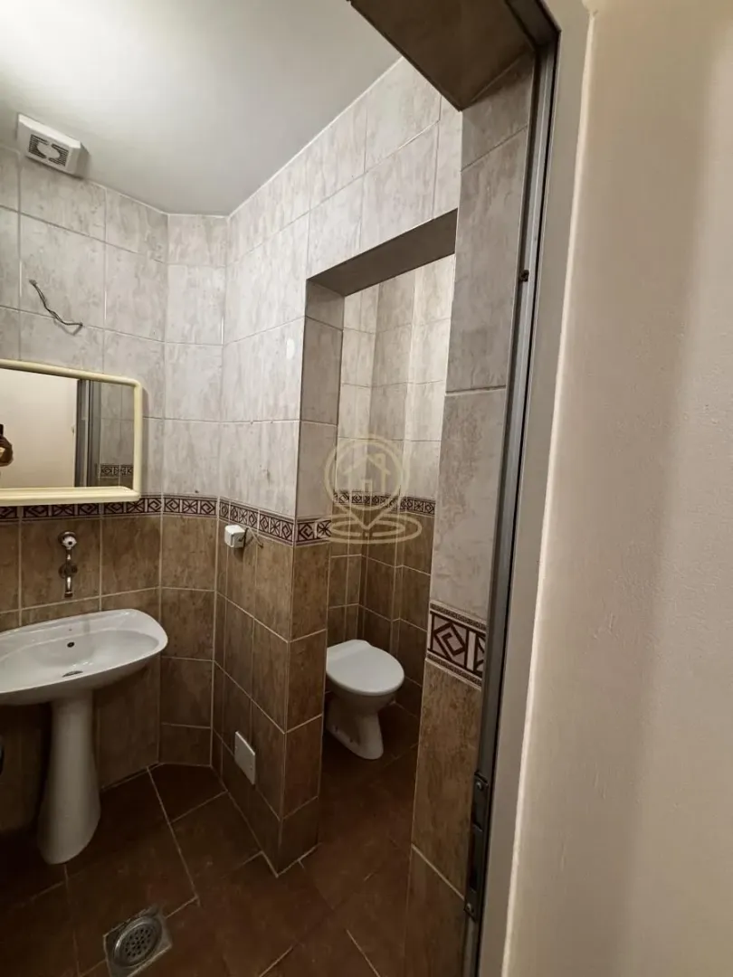 Smaller tiled bathroom with a sink and a toilet.