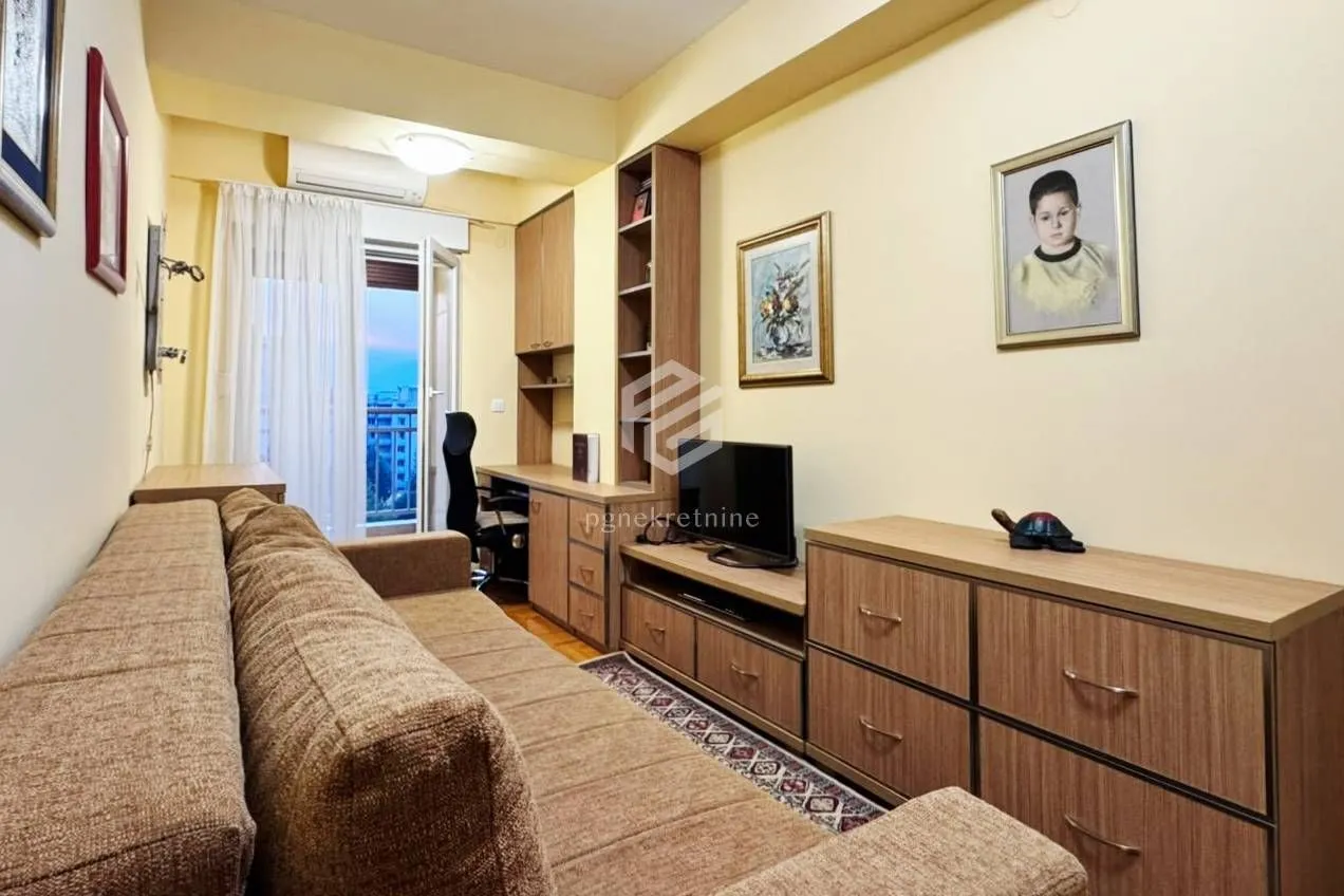 Living room with a sofa, TV cabinet, and a desk.