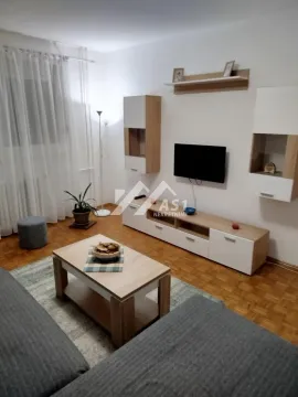 Nameštena dnevna soba sa garniturom, TV-om i drvenim nameštajem. - image 2