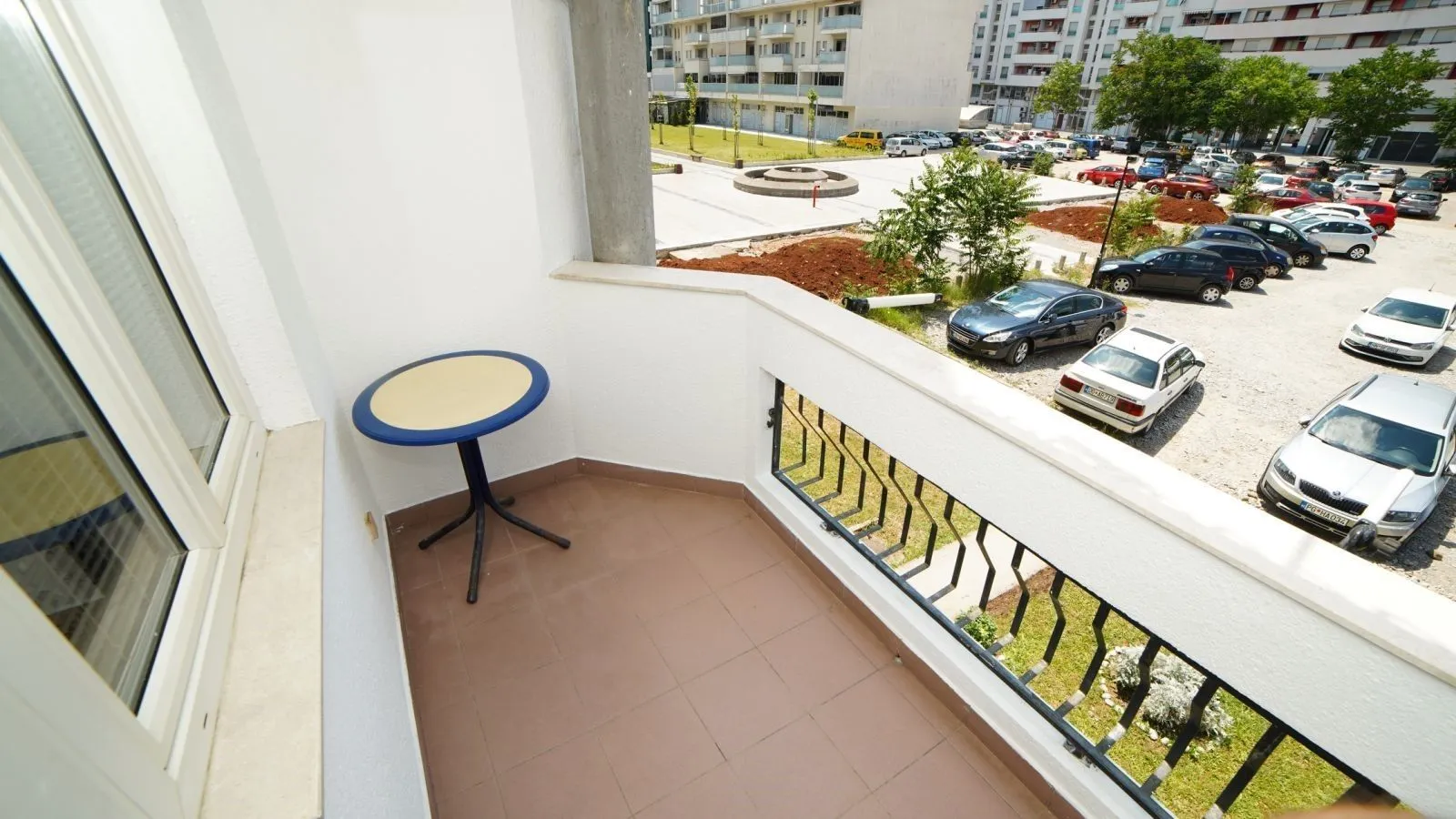 A balcony with a small table and a view of the surroundings.