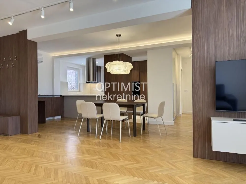 Living room with dining area and modern wooden wall paneling.