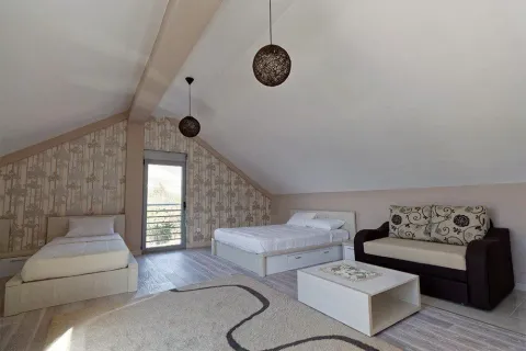 Attic bedroom furnished with two single beds, a double bed and a sofa. - image 12
