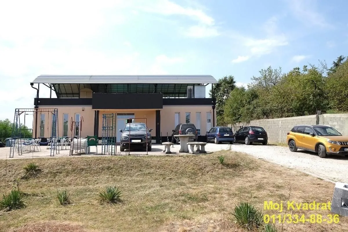 Exterior view of the building with yard and parking.