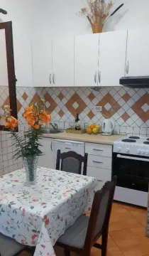 Manja kuhinja sa bijelim elementima, šporetom i trpezarijskim stolom. - image 2