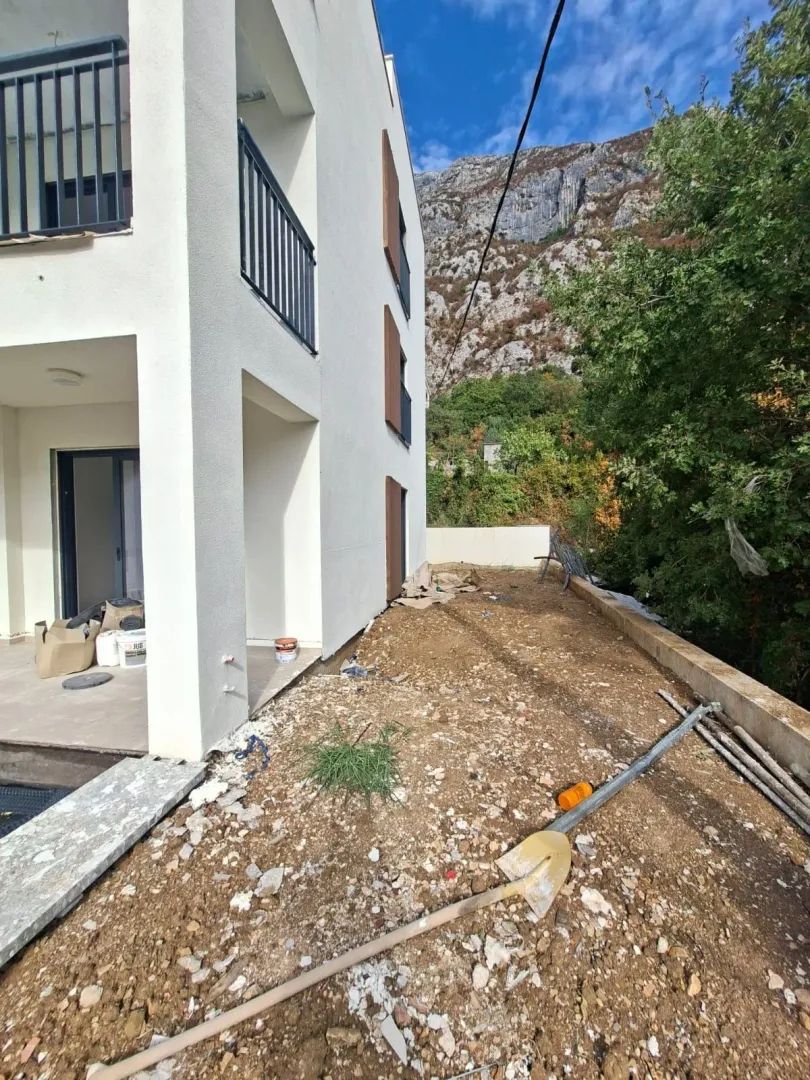 Pogled na spoljašnjost zgrade sa dvorištem u fazi uređenja.