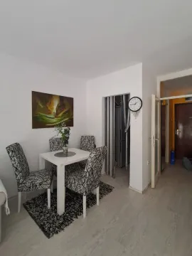Dining area with a table, four chairs, and a painting on the wall. - image 8