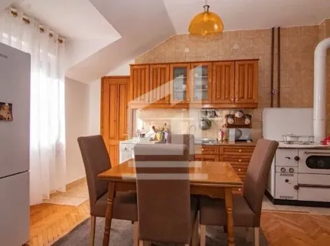 Kitchen with dining area and wooden cabinets. - image 7