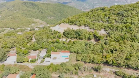 Pogled iz vazduha na imanje sa kućom i bazenom okruženo šumom i brdima. - image 2