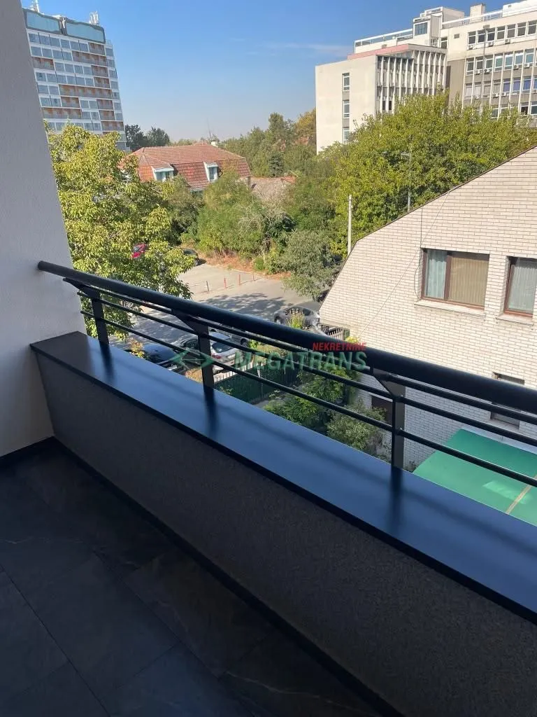 Pogled sa balkona na gradsku ulicu i okolne zgrade.