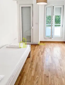 Svjetla spavaća soba sa krevetom i izlazom na balkon. - image 8