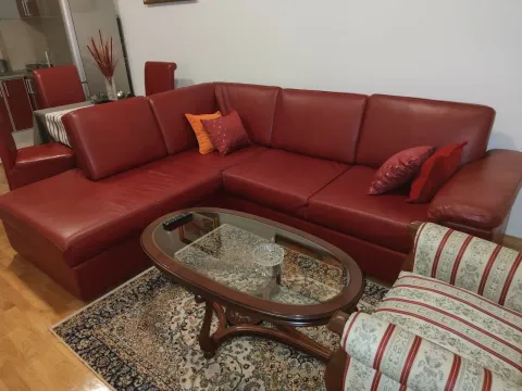 A living room featuring a large red leather corner sofa and a glass coffee table. - image 7