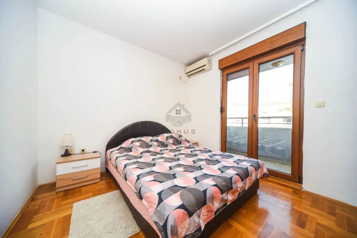 Bedroom with a double bed, bedside table, and access to the terrace.