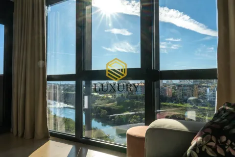 Bright living room with large glass surfaces and a river view. - image 8
