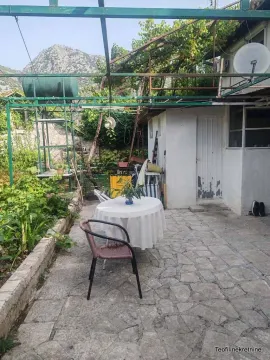 Popločano dvorište sa stolom, stolicama i metalnom konstrukcijom. - image 4