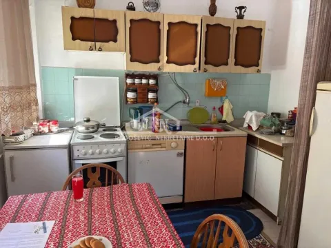 Starija kuhinja sa drvenim elementima i trpezarijskim stolom. - image 7