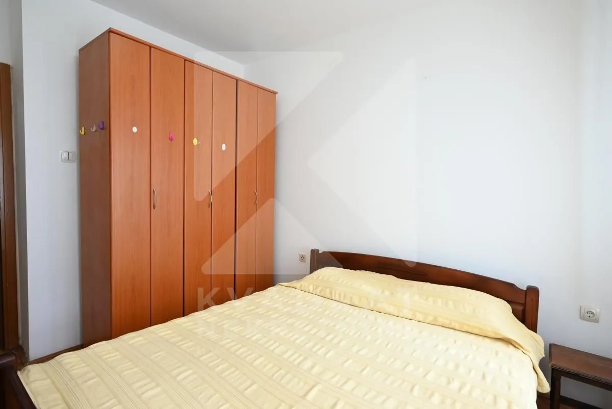 Bedroom with a double bed and a wooden wardrobe.