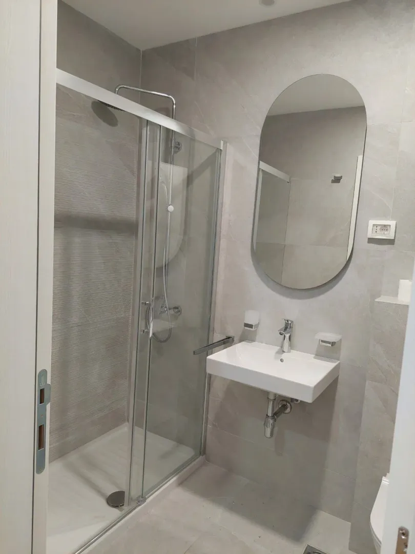 Modernly equipped bathroom with a shower cabin and a sink.
