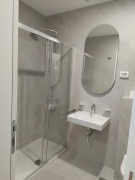 Modernly equipped bathroom with a shower cabin and a sink. - image 4